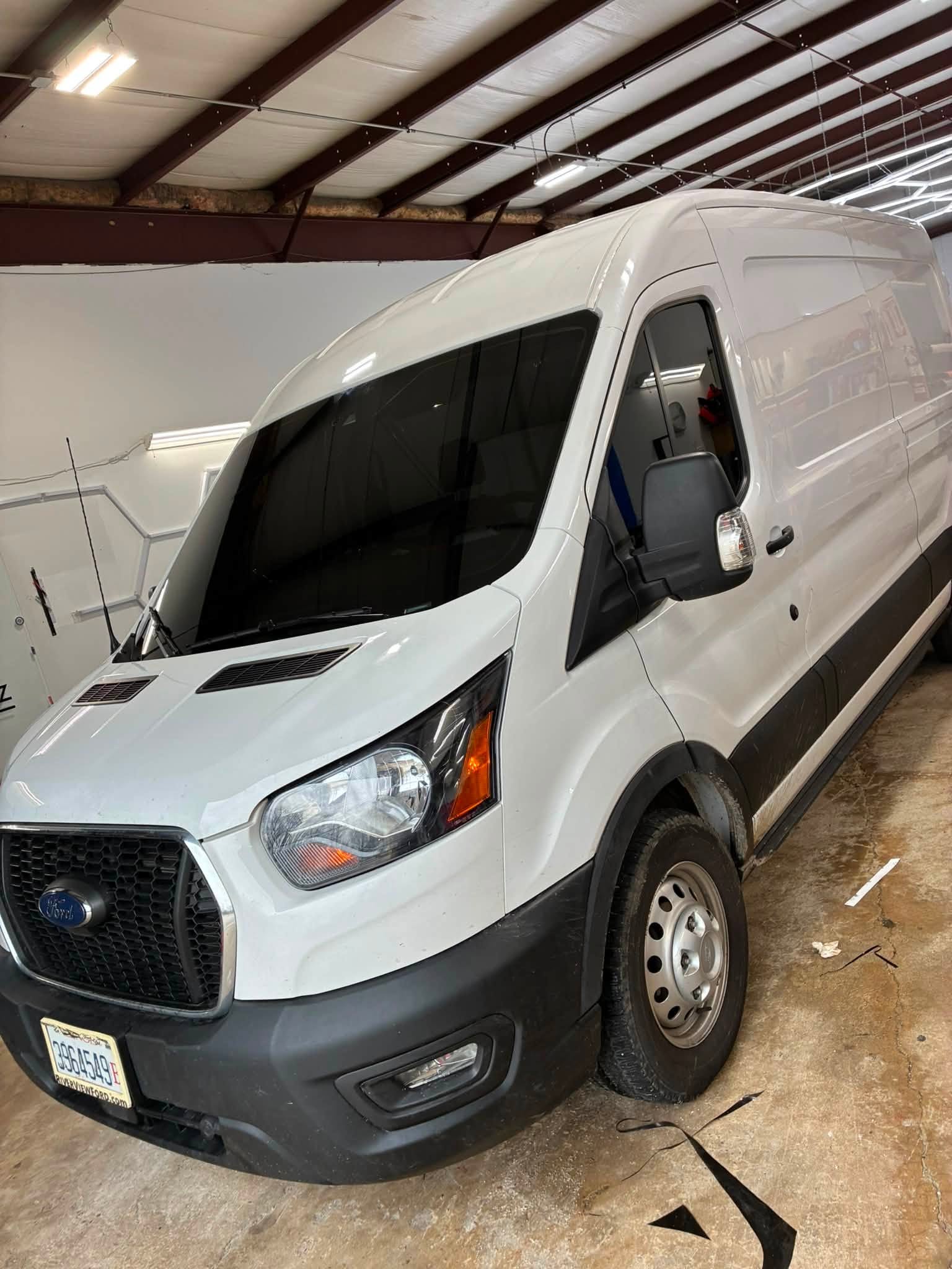 White Ford Transit cargo van with tinted windows inside the Prime Auto Lab shop